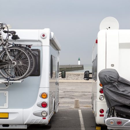 Two mobile homes from behind with the lighthouse of Calais in background