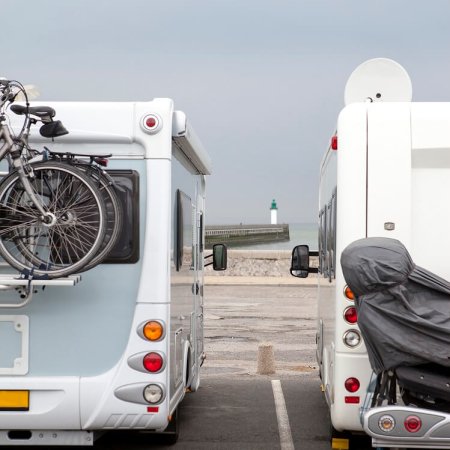 Two mobile homes from behind with the lighthouse of Calais in background